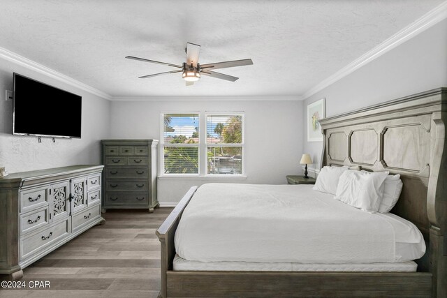 bedroom featuring ornamental molding, hardwood / wood-style floors, and ceiling fan