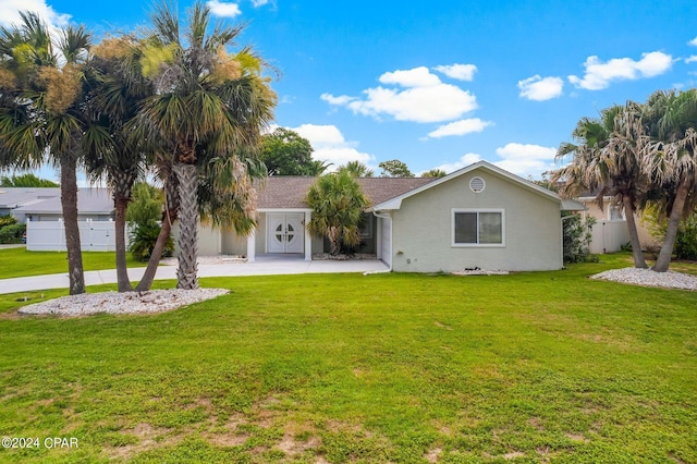 ranch-style house featuring fence, a front lawn, and stucco siding