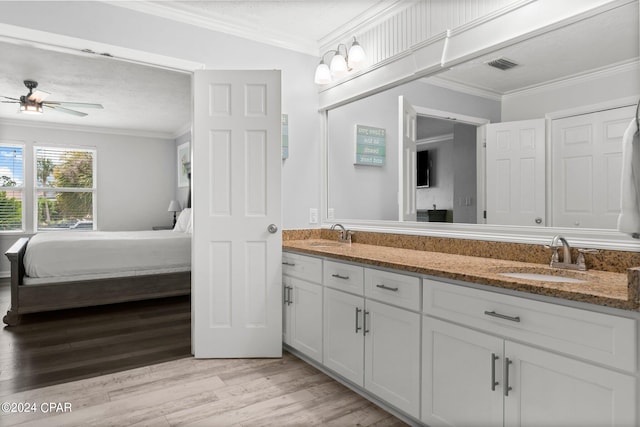 bathroom featuring double vanity, hardwood / wood-style flooring, crown molding, and ceiling fan