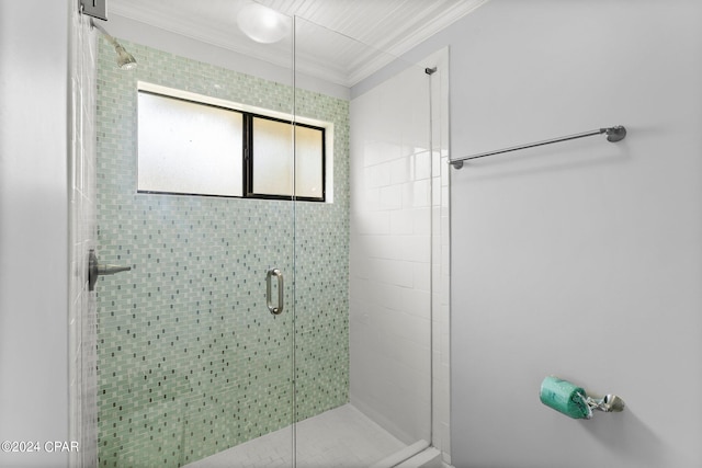 bathroom featuring ornamental molding and an enclosed shower