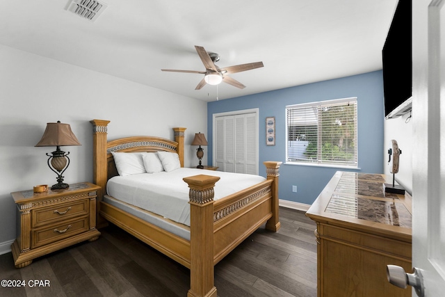 bedroom with a ceiling fan, visible vents, baseboards, a closet, and dark wood finished floors