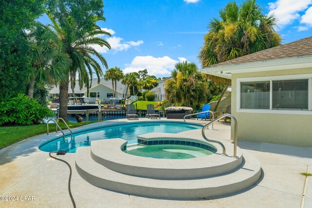 view of pool featuring a patio and an in ground hot tub