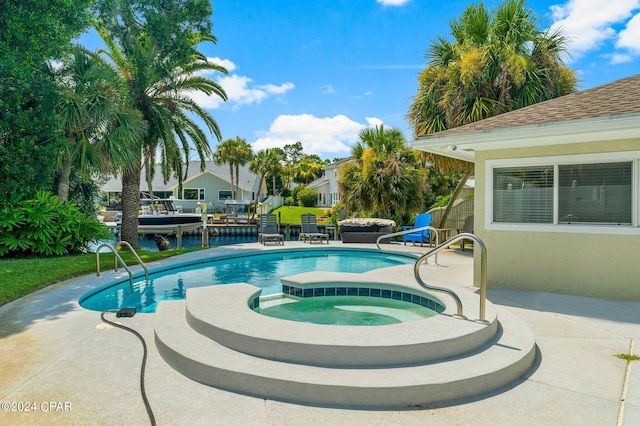 pool featuring a patio area and an in ground hot tub