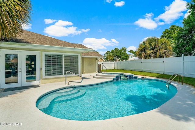 view of swimming pool featuring a fenced backyard, a pool with connected hot tub, a patio, and french doors