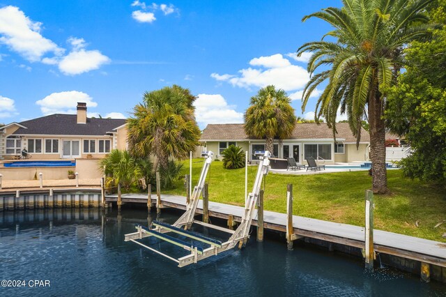 view of dock featuring a water view and a yard