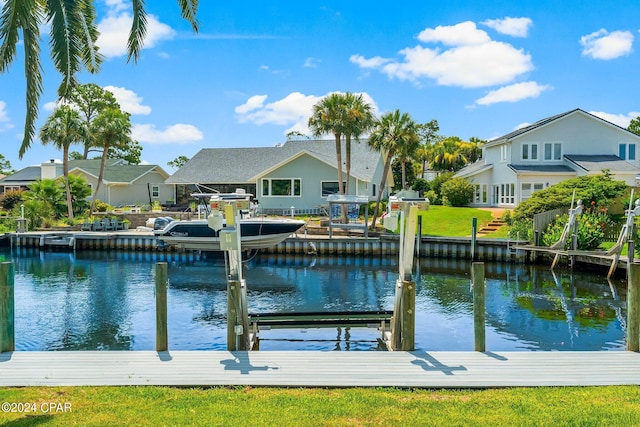 dock area with a water view, boat lift, and a residential view