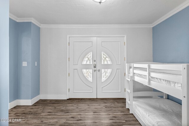 entryway with french doors, wood-type flooring, and ornamental molding