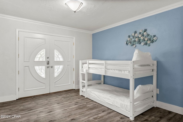 entrance foyer with baseboards, french doors, wood finished floors, and crown molding