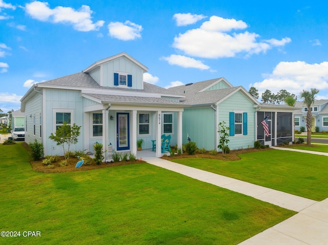 view of front of house featuring a front lawn and a sunroom