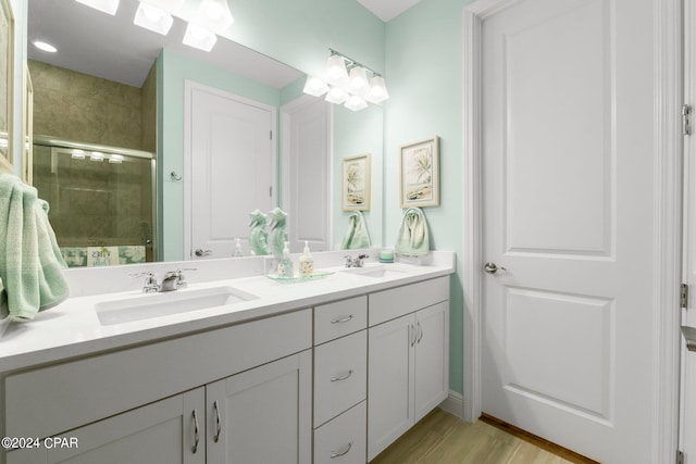 bathroom featuring wood-type flooring, walk in shower, and vanity