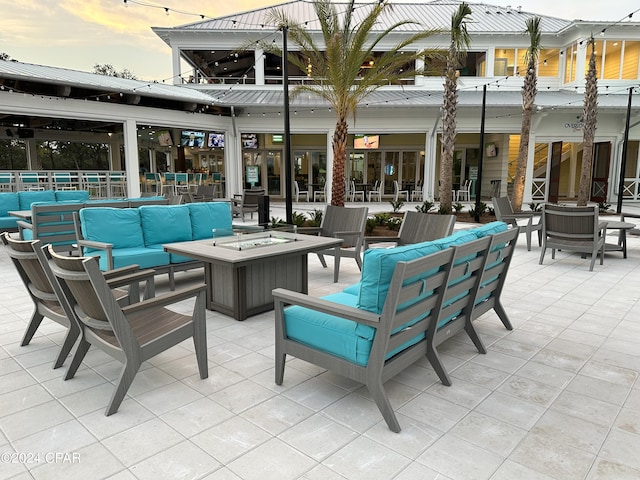 patio terrace at dusk featuring an outdoor living space with a fire pit