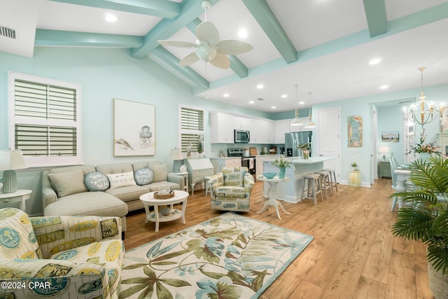 living room with ceiling fan with notable chandelier, light wood-type flooring, and vaulted ceiling with beams