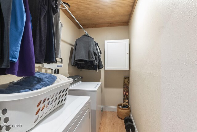 laundry room with separate washer and dryer, wooden ceiling, and light wood-type flooring