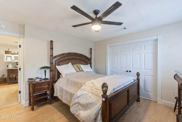 bedroom with ceiling fan, light hardwood / wood-style flooring, and a closet