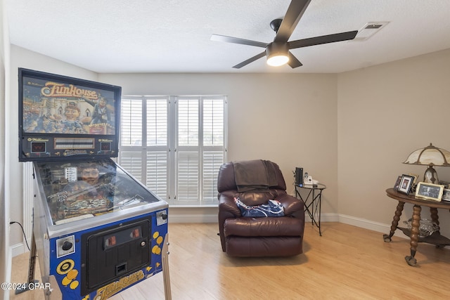 interior space with ceiling fan, light hardwood / wood-style floors, and a textured ceiling