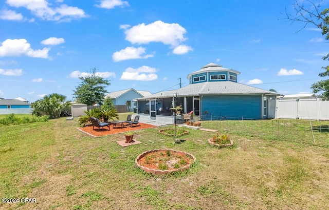 rear view of house with a shed, a patio area, and a lawn