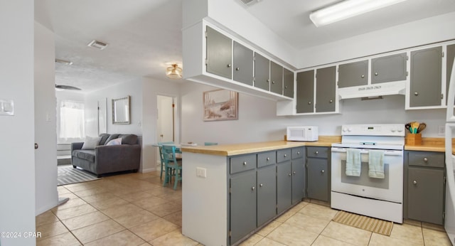 kitchen featuring open floor plan, under cabinet range hood, white appliances, and gray cabinetry