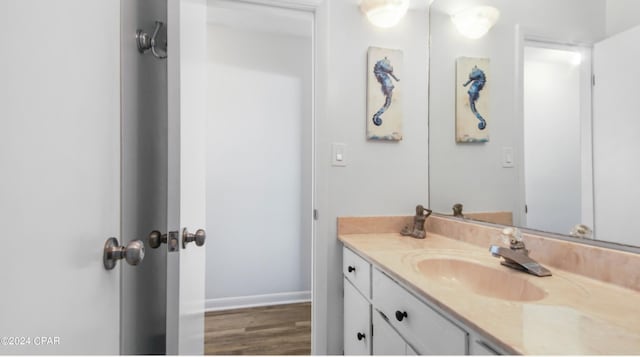 bathroom featuring baseboards, wood finished floors, and vanity