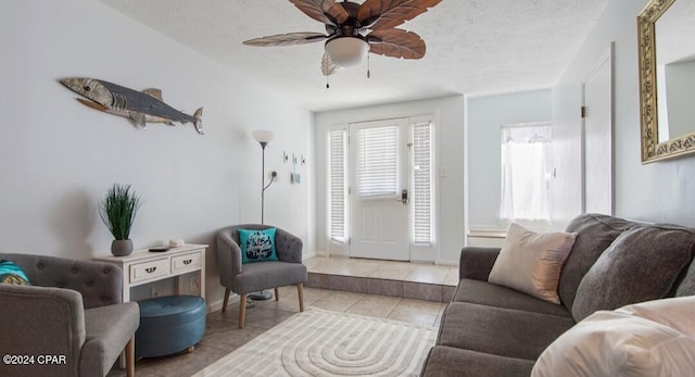 tiled living area featuring a ceiling fan and a textured ceiling