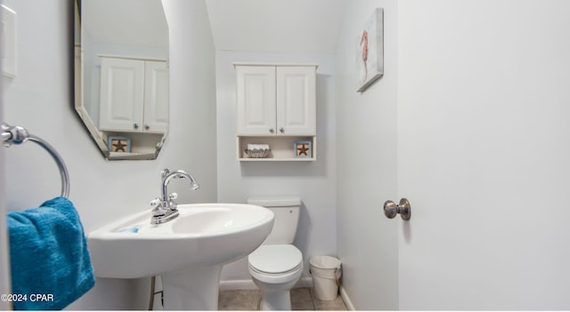 bathroom featuring toilet, tile patterned flooring, baseboards, and a sink