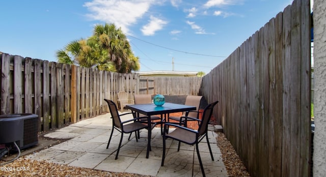 view of patio / terrace with outdoor dining space, a fenced backyard, and central air condition unit