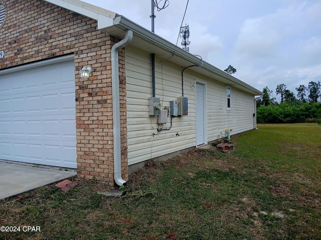 view of side of home with a yard and a garage