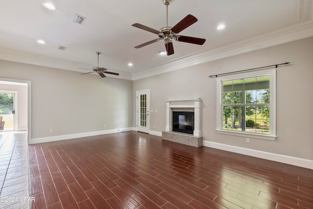 unfurnished living room with ornamental molding, ceiling fan, a fireplace, and dark hardwood / wood-style floors