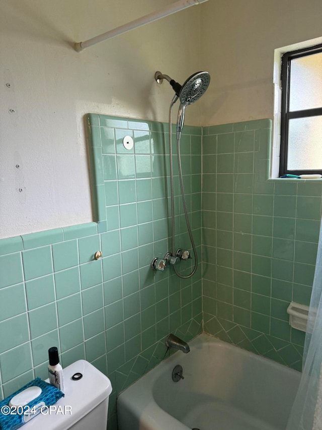 bathroom with shower / bath combination with curtain, tile walls, and toilet