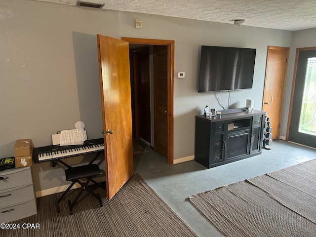 office space with a textured ceiling and dark colored carpet