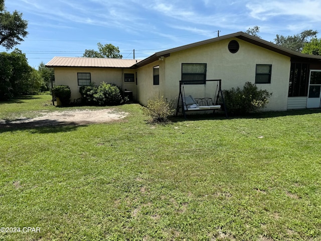 back of property featuring a lawn