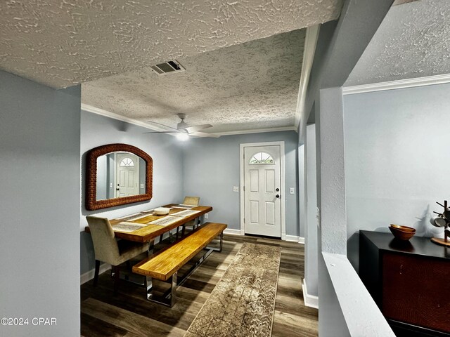 interior space featuring dark hardwood / wood-style floors, crown molding, and a textured ceiling