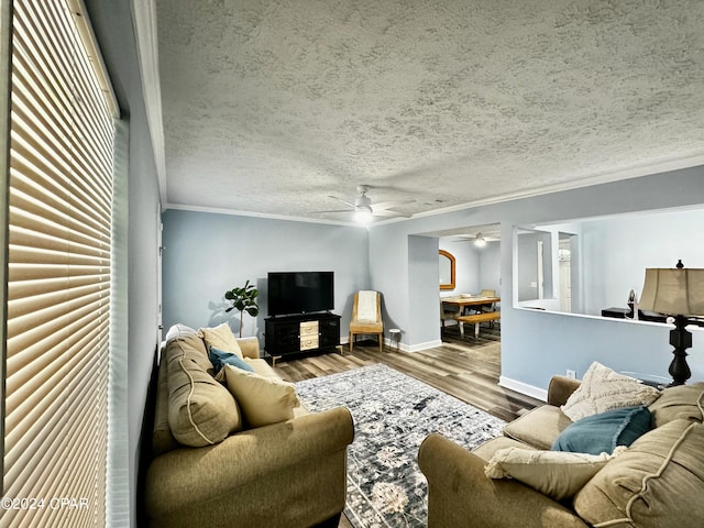 living room with a textured ceiling, ceiling fan, hardwood / wood-style floors, and crown molding