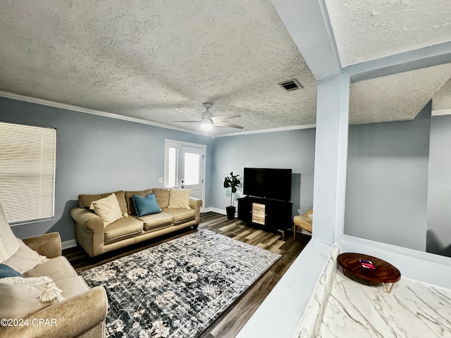 living room featuring ceiling fan, dark hardwood / wood-style floors, crown molding, and a textured ceiling