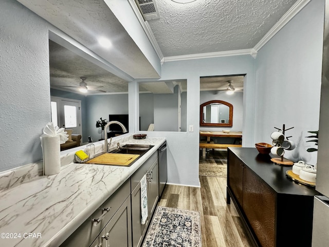 kitchen with crown molding, light wood finished floors, stainless steel dishwasher, ceiling fan, and a textured ceiling