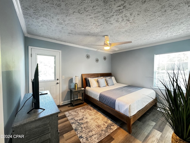 bedroom featuring ceiling fan, a textured ceiling, crown molding, and dark wood-type flooring