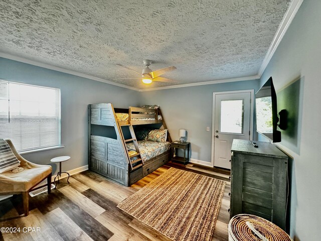 bedroom with crown molding, hardwood / wood-style floors, and a textured ceiling