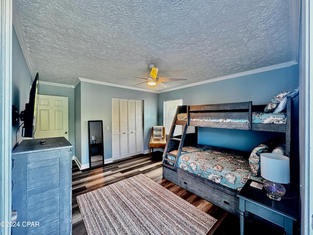 bedroom with a closet, a textured ceiling, dark wood-type flooring, ceiling fan, and ornamental molding