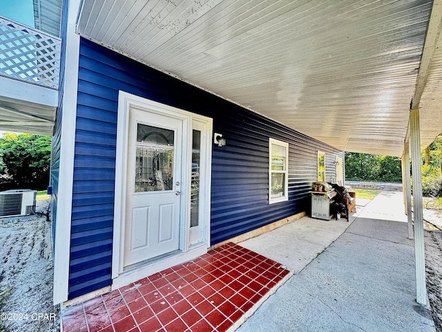 doorway to property with covered porch and central air condition unit