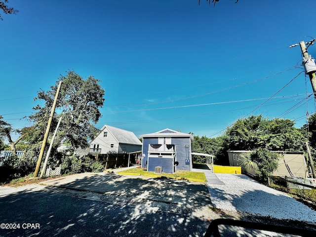 view of front of house with fence and an outdoor structure