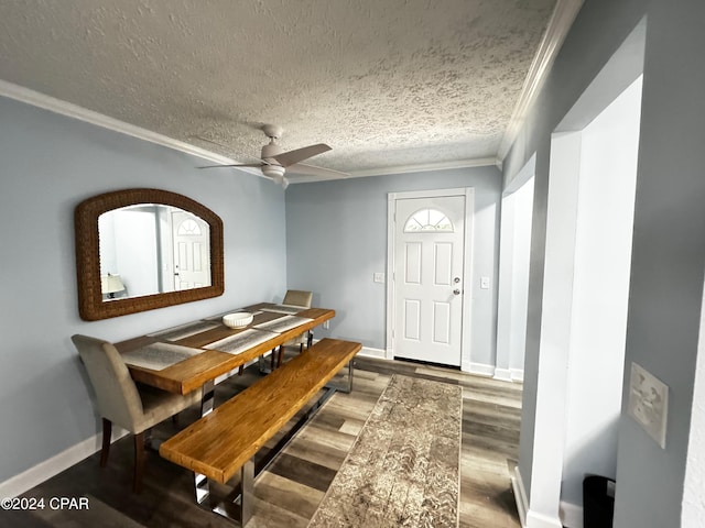 dining space with ceiling fan, a textured ceiling, wood finished floors, baseboards, and crown molding