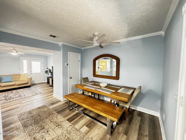 dining room with crown molding, a textured ceiling, ceiling fan, and hardwood / wood-style floors