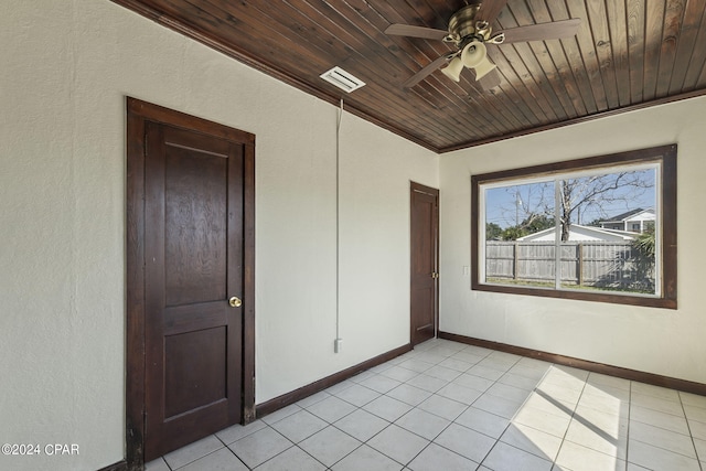 tiled spare room with ornamental molding, ceiling fan, and wooden ceiling