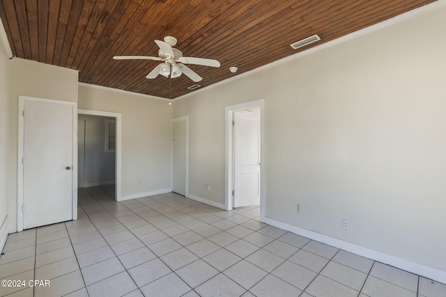 unfurnished room with ceiling fan, wooden ceiling, ornamental molding, and light tile patterned floors