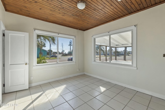 spare room featuring plenty of natural light, light tile patterned floors, wood ceiling, and ornamental molding