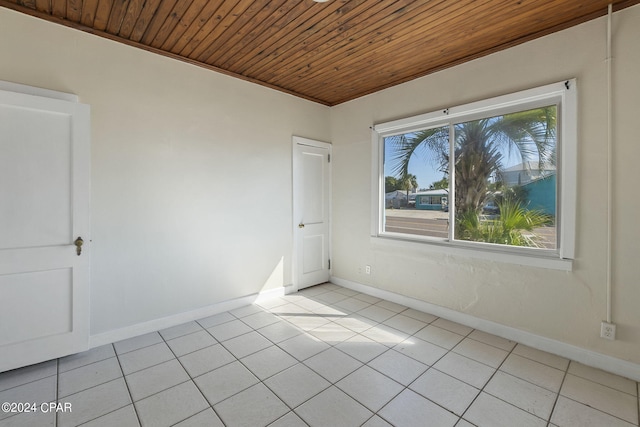 empty room with light tile patterned flooring and wooden ceiling