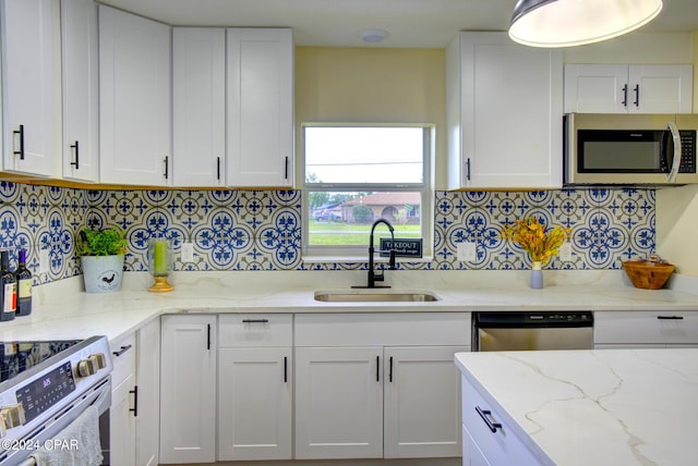 kitchen with sink, decorative backsplash, white cabinetry, and appliances with stainless steel finishes