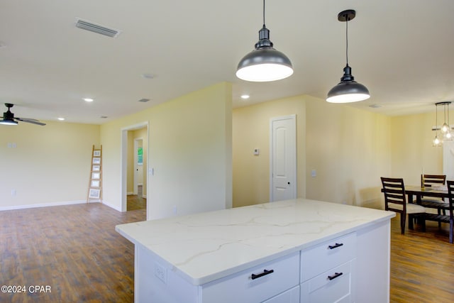 kitchen with white cabinetry, ceiling fan, pendant lighting, and light stone countertops