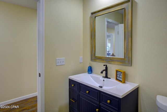 bathroom featuring toilet, hardwood / wood-style floors, and vanity