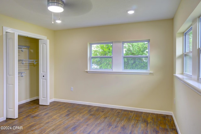 unfurnished bedroom with ceiling fan, a closet, and dark hardwood / wood-style floors