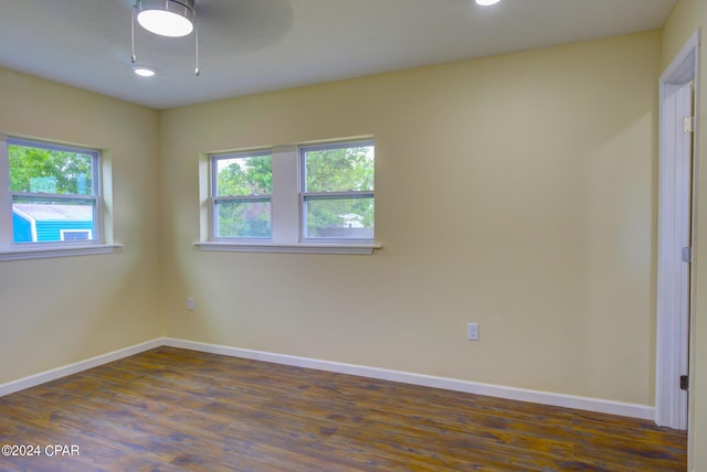 spare room with dark wood-type flooring and ceiling fan